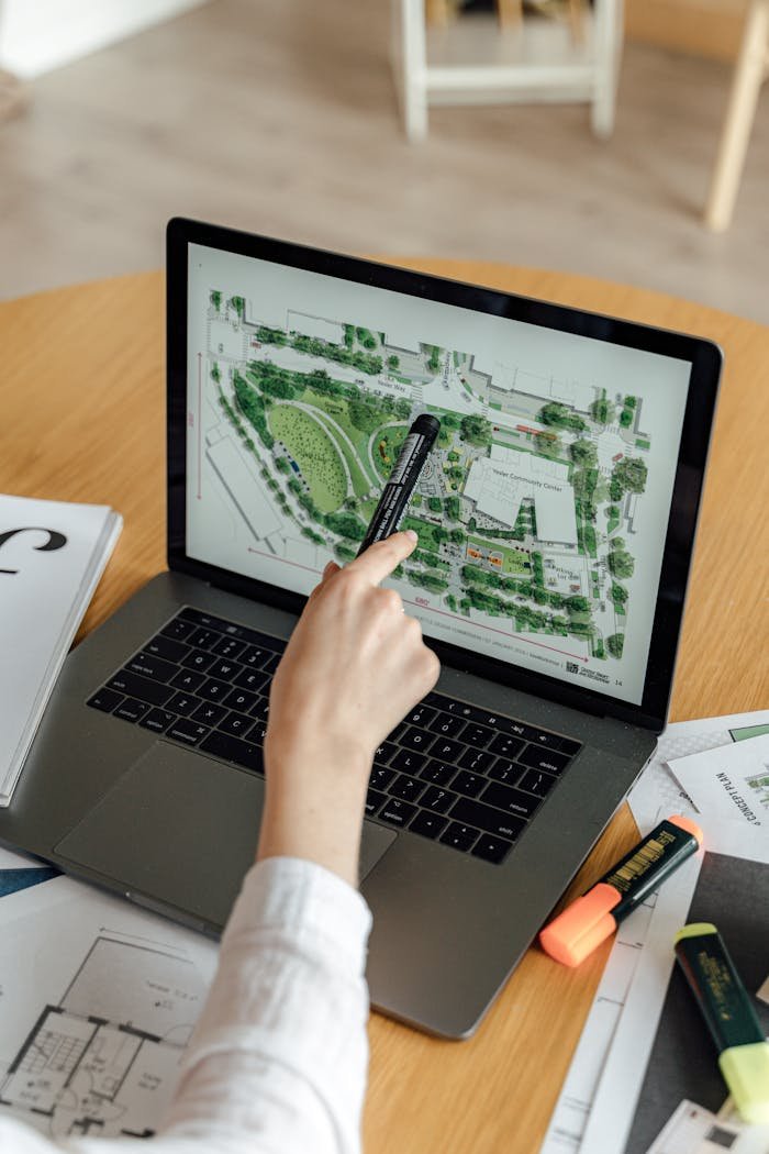 Person Using Macbook Pro on Brown Wooden Table